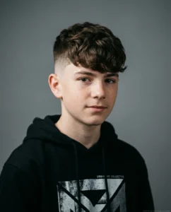Medium High Fade with Textured Fringe on wavy hair